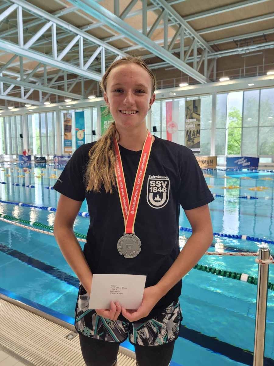 Jugendliche Schwimmerin mit Medaille SSV 1846 Shirt und Umschlag am Beckenrand