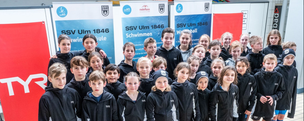 SSV Ulm 1846 Nachwuchsschwimmer in schwarzen Vereinsjacken am Beckenrand