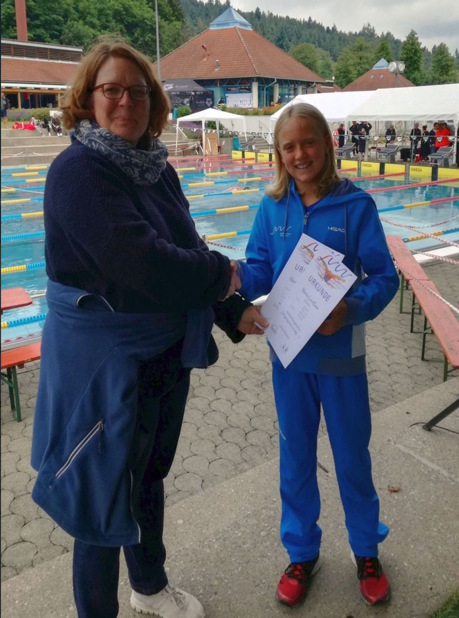 Jugendlicher Schwimmer erhält Urkunden durch Handschlag am Wettkampfbecken