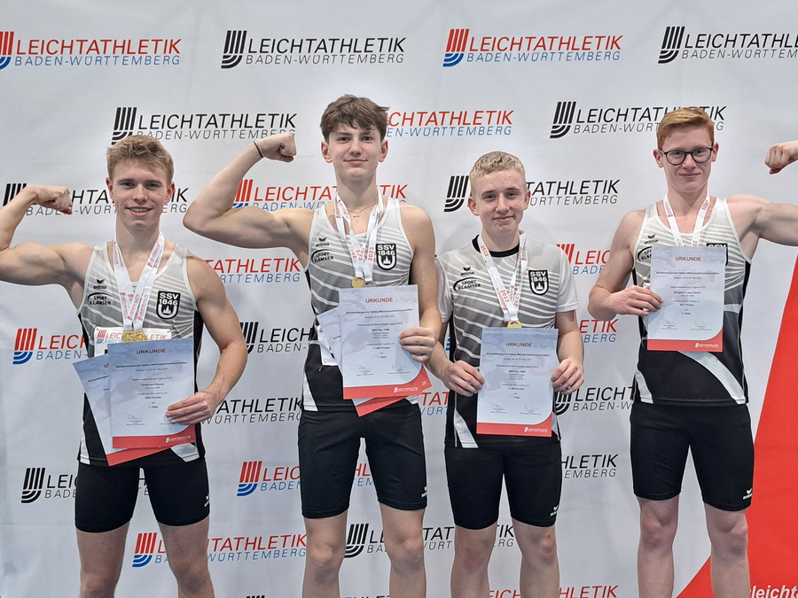 Vier jugendliche Athleten mit Medaillen und Urkunden vor Leichtathletik Baden-Württemberg Banner