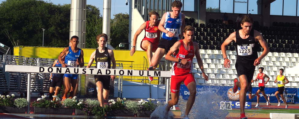 Hindernisläufer springen über Wassergraben im Donaustadion Ulm