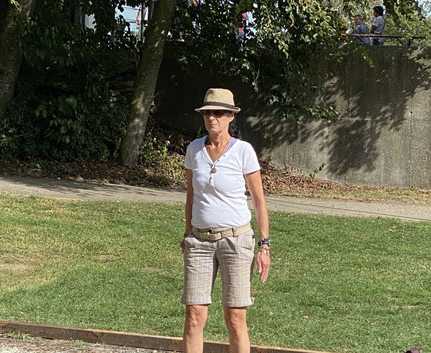 Frau mit Sonnenhut und Sonnenbrille auf Bouleplatz