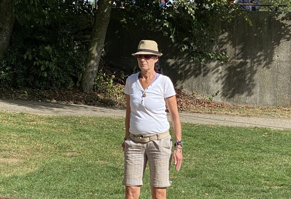Frau mit Sonnenhut und Sonnenbrille auf Bouleplatz