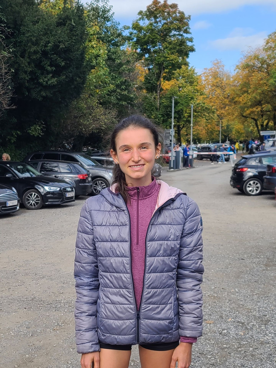 Läuferin nach Straßenlauf in lila Steppjacke und kurzen Hosen