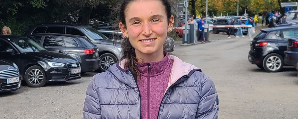 Läuferin nach Straßenlauf in lila Steppjacke und kurzen Hosen