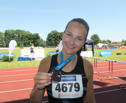Franziska Wloka Smiling female athlete showing medal bib 4679