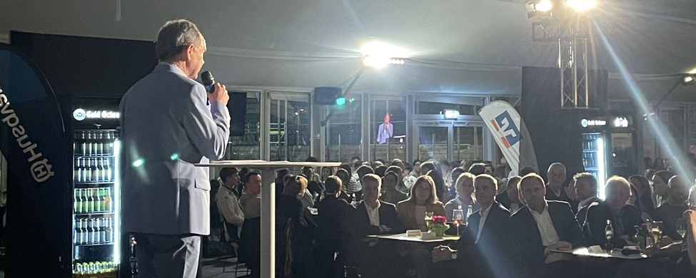 Inspirierende Rede beim SSV Ulm 1846 e.V.-Event Redner im Anzug auf Bühne bei Sportlerehrung, Publikum an Tischen