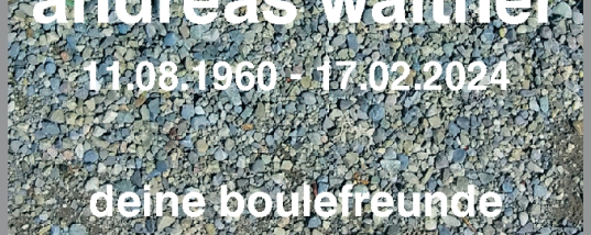 Kiesfläche mit drei Boulekugeln und Trauertext mit Namen und Daten