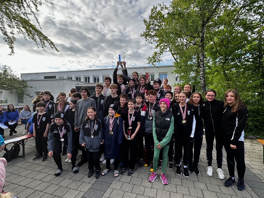 Jugendliche Schwimmerinnen und Schwimmer mit Medaillen und Pokal bei Siegerehrung