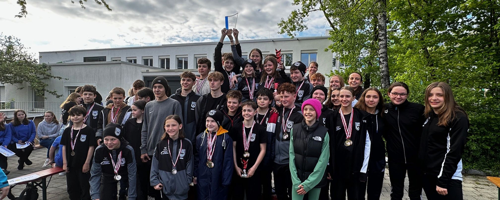 Jugendliche Schwimmerinnen und Schwimmer mit Medaillen und Pokal bei Siegerehrung