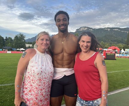 Drei Personen auf Leichtathletikplatz vor Anzeigetafel GOETZIS