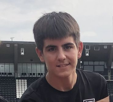Vier Jugendliche in Sportkleidung auf Laufbahn Hände zusammen vor Stadion