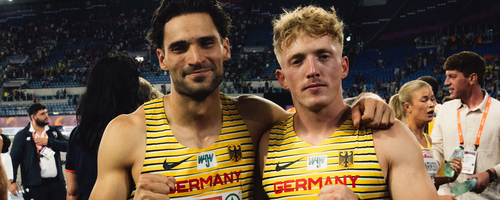Zwei Leichtathleten in gelben Germany-Trikots mit Startnummern ROMA 2024