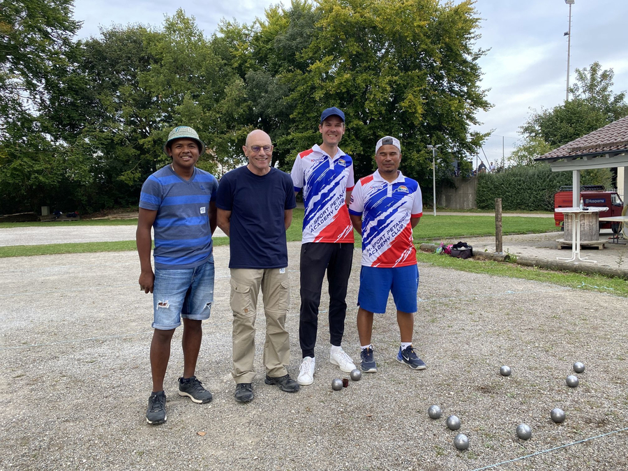 Vier Boulespieler stehen mit Kugeln im Vordergrund beim Boule Cup Beimerstetten