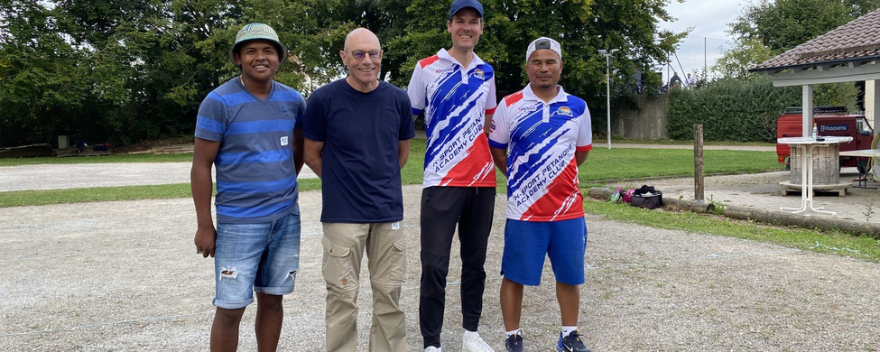 Vier Boulespieler stehen mit Kugeln im Vordergrund beim Boule Cup Beimerstetten