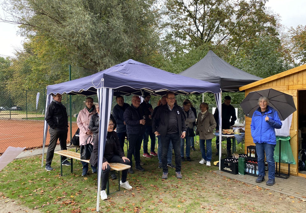 Gruppe von Personen unter Pavillons neben Tennisplatz Frau mit Regenschirm