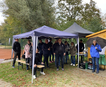 Gruppe von Personen unter Pavillons neben Tennisplatz Frau mit Regenschirm