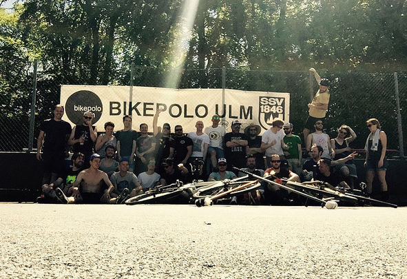 Gruppe von Personen vor Banner mit Bikepolo Ulm und Fahrrädern