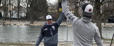 Zwei Männer beim Outdoortraining mit Kettlebell am Flussufer bei winterlichem Wetter