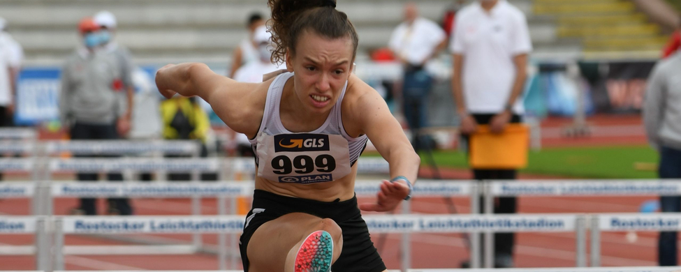 Hürdensprinterin mit Bib 999 über Rostocker Leichtathletikstadion