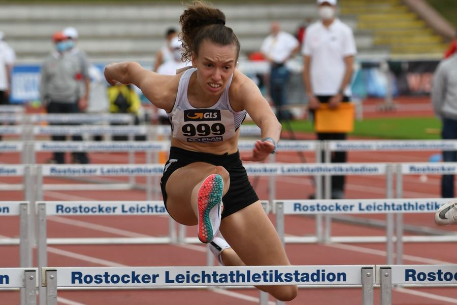 Hürdensprinterin mit Bib 999 über Rostocker Leichtathletikstadion