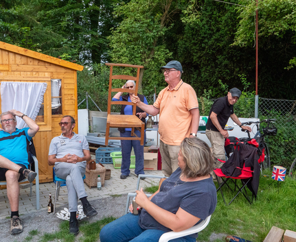 Teilnehmer beim Sonntagsturnier, Mann hält Holzstuhl hoch