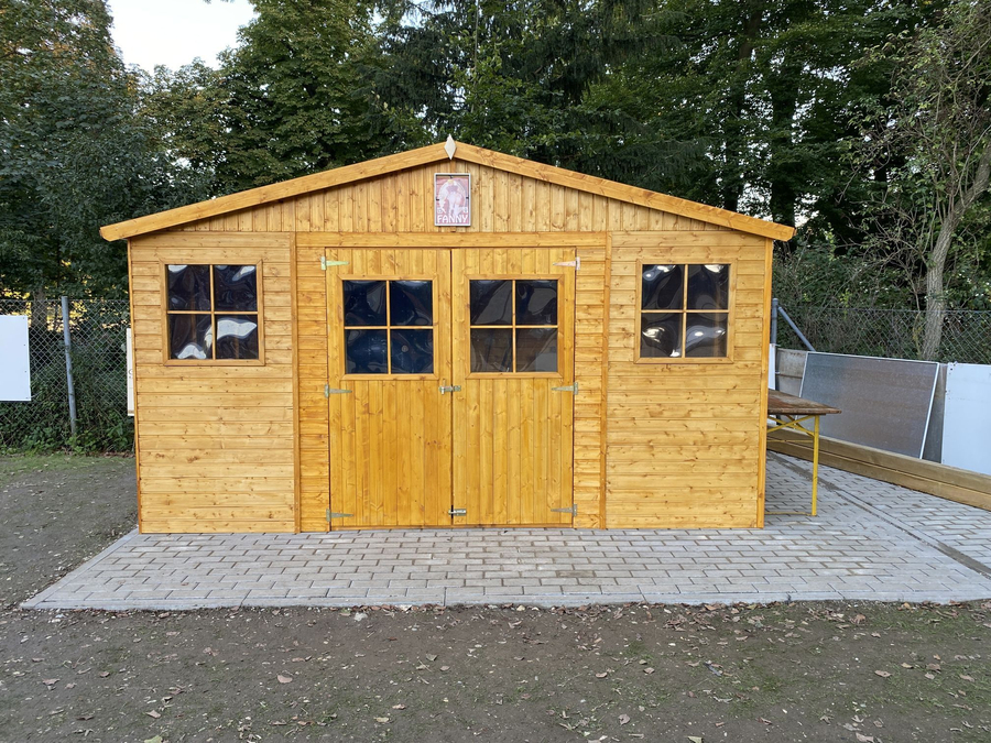 Holzschuppen mit Doppeltür und Seitenfenstern auf gepflastertem Untergrund