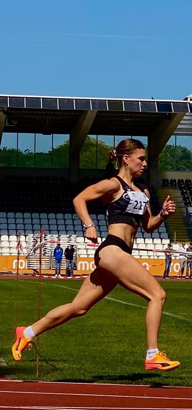 Weibliche Sprinterin mit Startnummer 217 im vollen Sprint