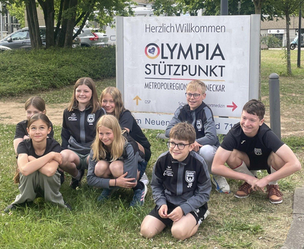 Jugendliche Schwimmer vor Schild Herzlich Willkommen Olympia Stützpunkt