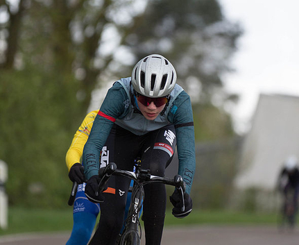 Radrennfahrer in Aeroposition vorn Verfolger in gelbem Trikot beim Rennen
