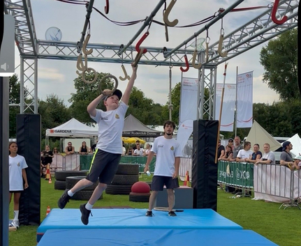 Teilnehmender am Ninja-Parcours greift hängende Ringe beim Sportfest