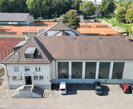 Gebäude mit Schild Gaststätte Jahnhalle und Tennisplätze im Hintergrund
