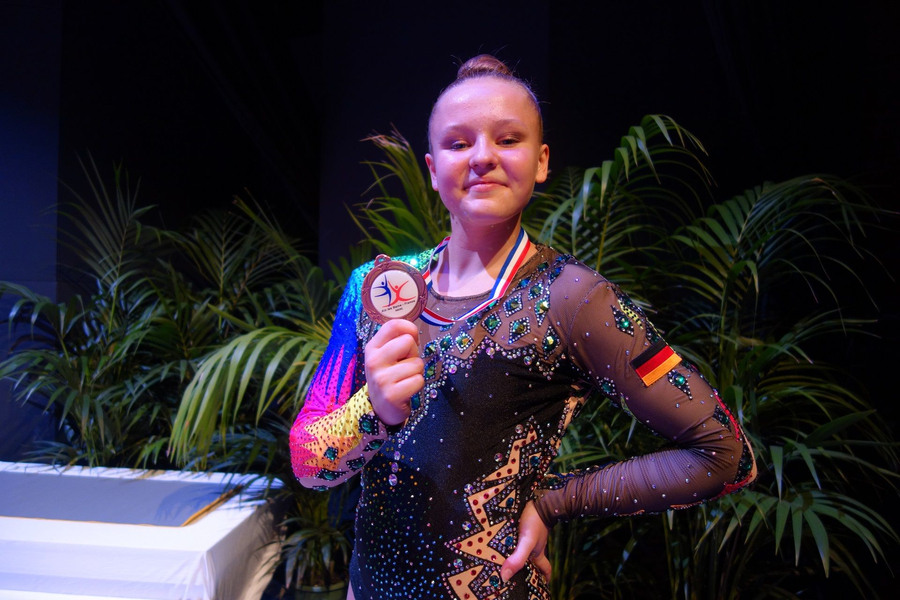 Turnerin mit Bronzemedaille und deutschem Flaggenaufnäher