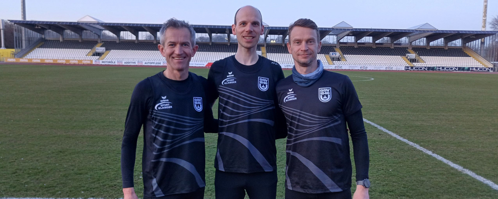 Drei Läufer des SSV 1846 in Trainingsshirts auf Stadionrasen
