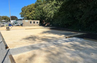 Unfinished gravel courts with wooden borders and construction container