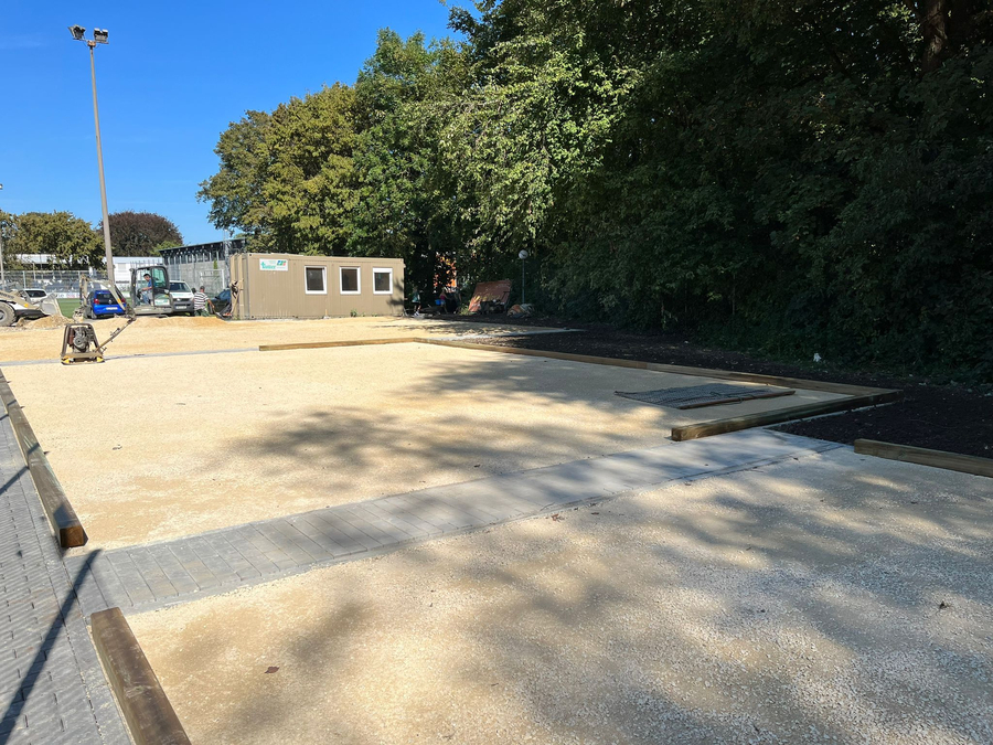 Unfinished gravel courts with wooden borders and construction container