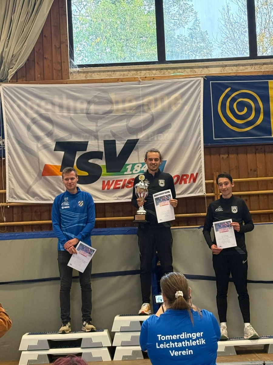 Drei Athleten auf Siegerpodest mit Pokal und Shirttext Tomerdinger Leichtathletik Verein