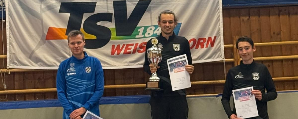 Drei Athleten auf Siegerpodest mit Pokal und Shirttext Tomerdinger Leichtathletik Verein