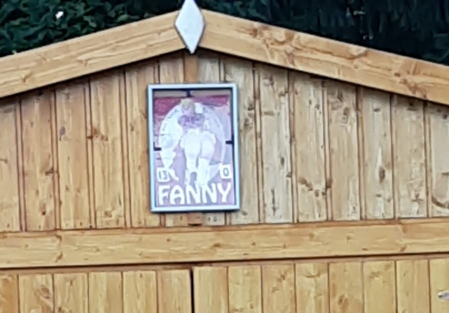 Holzschuppen mit Doppeltür, Sprossenfenstern und Schild Fanny