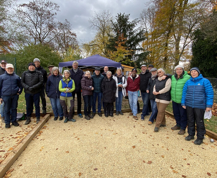 Gruppe Erwachsener auf Bouleplatz vor Pavillon im Herbst
