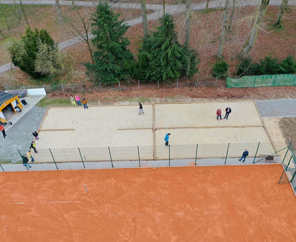 Aerial view of people playing ball game on sand courts
