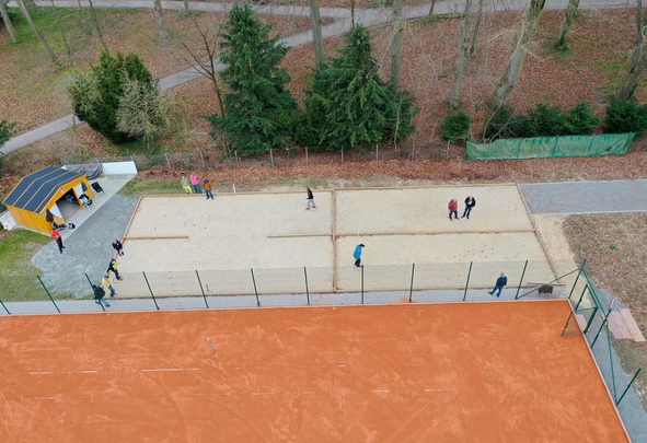 Aerial view of people playing ball game on sand courts