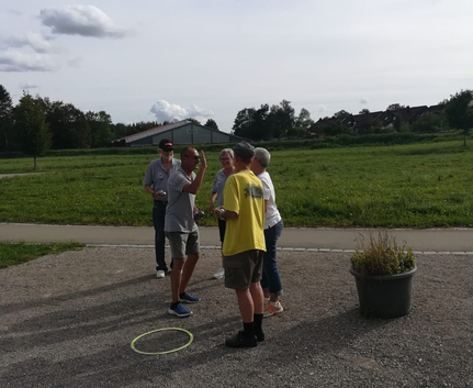 Gruppe beim Boule-Freundschaftsspiel auf Kiesplatz in Krumbach