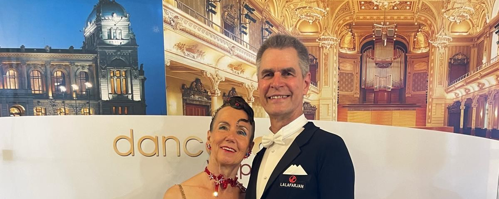 Tanzpaar in rotem Kleid und Frack vor danceComp Wuppertal Banner