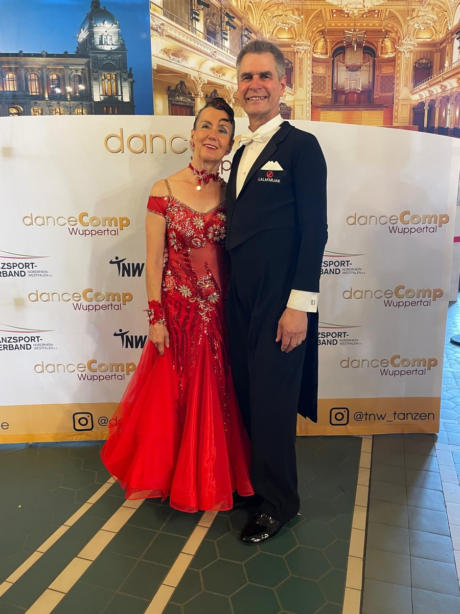 Tanzpaar in rotem Kleid und Frack vor danceComp Wuppertal Banner