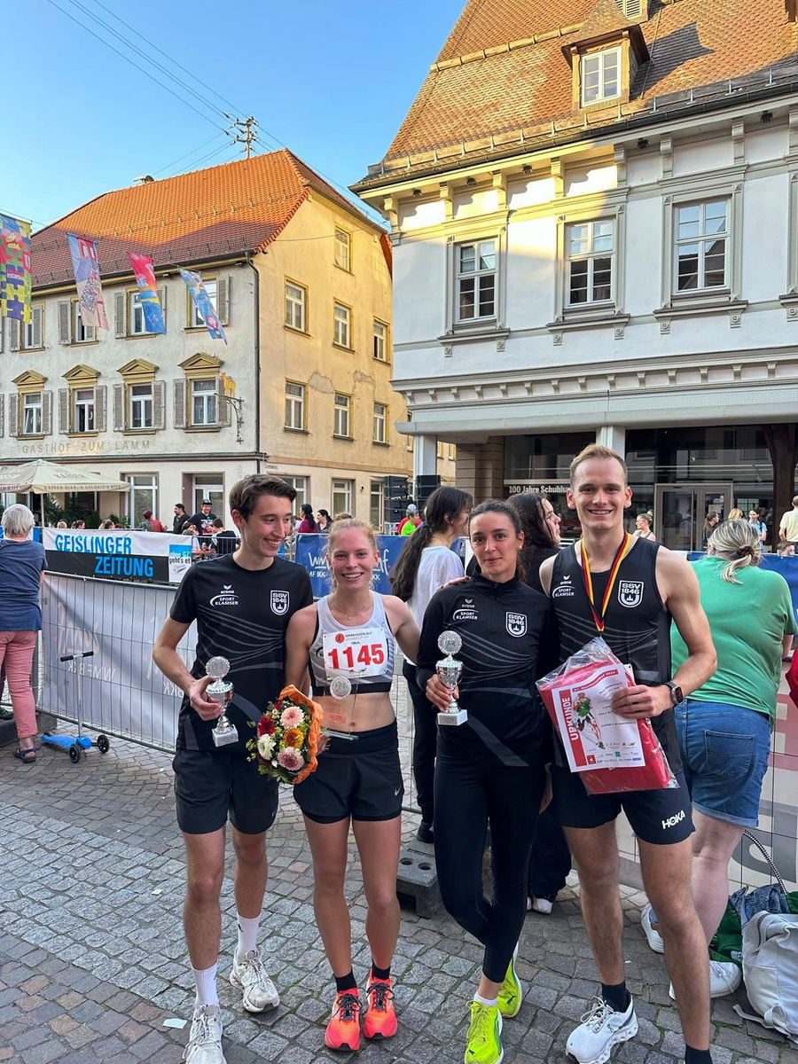 Vier Läuferinnen und Läufer mit Pokalen und Starternummer 1145 sichtbar