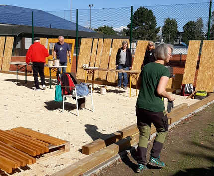 Menschen bauen Holzpaneele an einem umzäunten Außenbereich