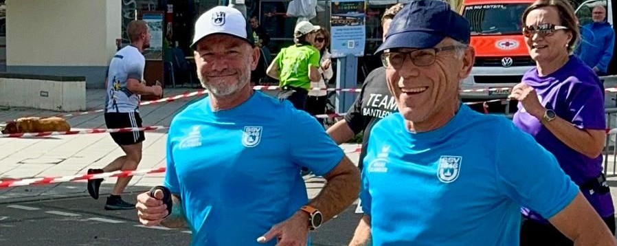 Zwei lächelnde Läufer in blauen Shirts beim 10-km-Lauf