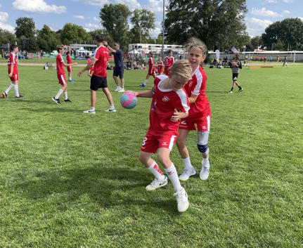Kinder in roten Trikots beim Ballspiel auf der Gänswiese