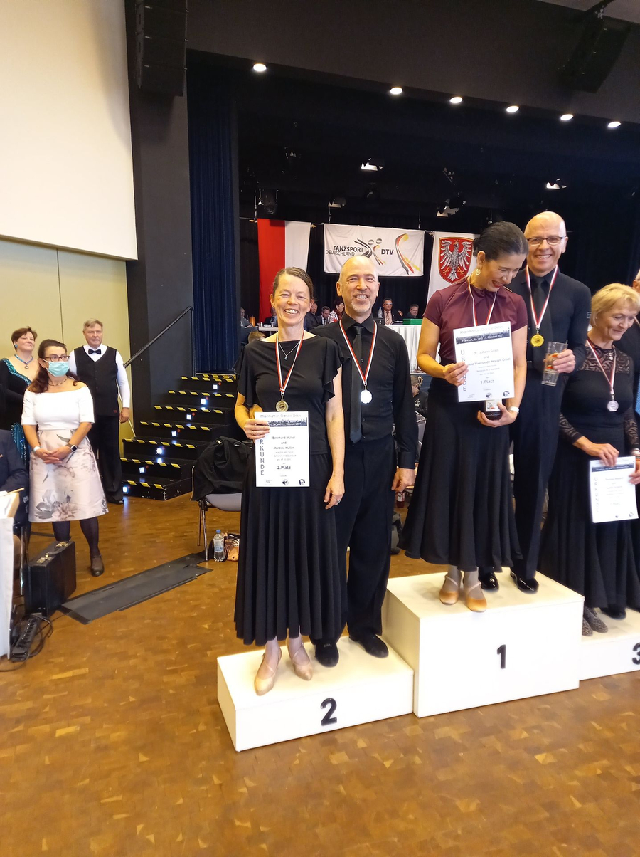 Mehrere Tanzpaare auf Siegerpodest mit Medaillen und Urkunden